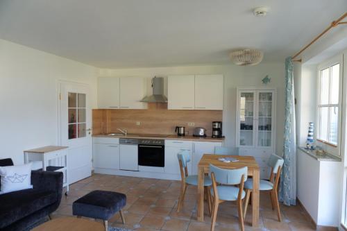 Una cocina y una sala de estar con mesa y sillas. en Birkenhof App 64, en Wustrow