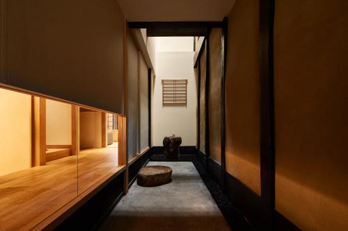 een gang van een huis met houten wanden en een kruk bij YADORU KYOTO HANARE Tsukikage No Yado in Kyoto
