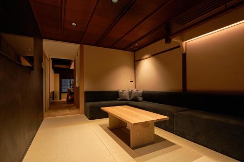 a living room with a couch and a wooden table at YADORU KYOTO HANARE Tsukikage No Yado in Kyoto