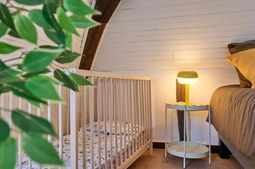 a crib in a room with a bed and a lamp at Le 70 - centre-ville - 2 parkings privé - TOUT INCLUS in Saint-Aignan