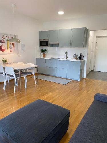 a living room with a table and a kitchen at Ebelsberger Terrassen in Linz