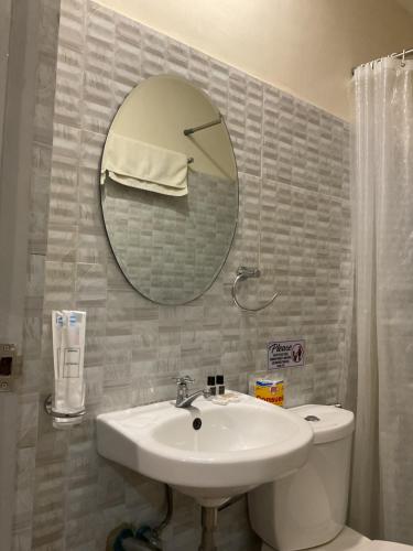 a bathroom with a sink and a mirror and a toilet at Belladama Hotel in San Carlos