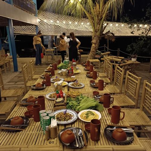 a long wooden table with plates of food on it at Ann Homestay in Can Tho