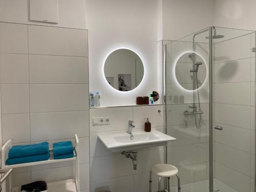 a white bathroom with a sink and a shower at Ebelsberger Terrassen in Linz