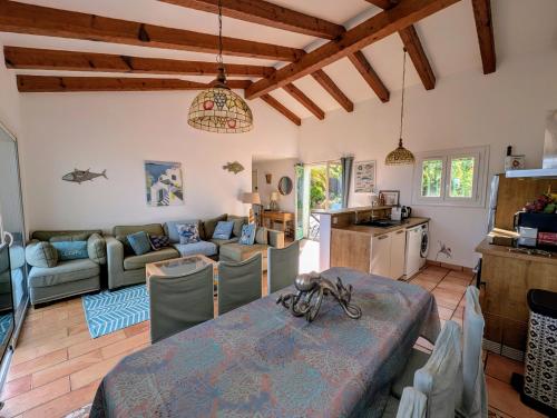 Il comprend un grand salon avec une table et une cuisine. dans l'établissement La villa Acacia, à Coti-Chiavari
