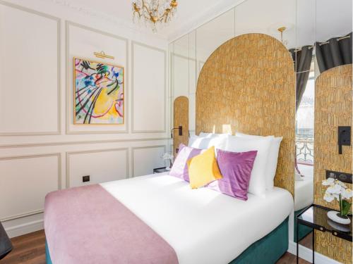 - une chambre avec un grand lit blanc et des oreillers colorés dans l'établissement Merveil - Luxury Suite - Opera - Septembre II, à Paris