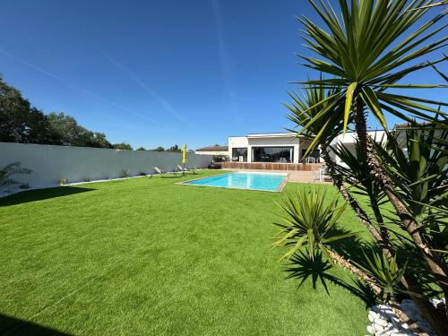 une cour avec une piscine et une pelouse verdoyante dans l'établissement Villa Noam Haut Standing 220m2, à Beauvoisin