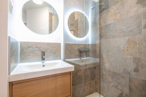 ein Badezimmer mit Waschbecken und Spiegel in der Unterkunft NOEMA - vue montagne in La Toussuire