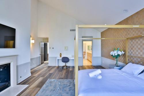 a bedroom with a bed and a living room with a fireplace at 6BR-Music Studio-Pool-Spa & Games in Sherman Oaks