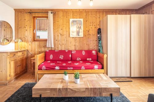 ein Wohnzimmer mit einem roten Sofa und einem Tisch in der Unterkunft NOEMA - vue montagne in La Toussuire