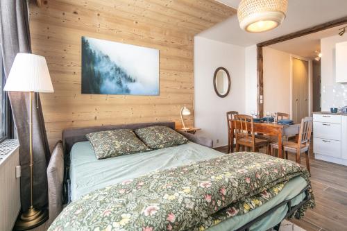 une chambre avec un lit, une table et un bureau dans l'établissement L'Eterlou - Chamrousse - Au pied des pistes, à Chamrousse