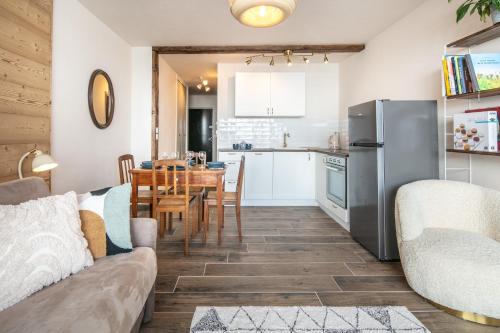 une cuisine et une salle à manger avec une table et un réfrigérateur dans l'établissement L'Eterlou - Chamrousse - Au pied des pistes, à Chamrousse