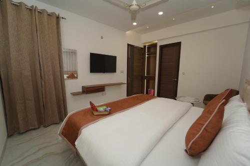 a bedroom with a large bed and a tv on the wall at Hotel Chandigarh Heights - Airport Road Manali Highway Transit Hotel in Kharar