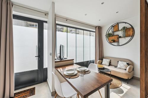 un salon avec une table et un canapé dans l'établissement Le Studio Scandinave - 25min de Paris, à Courbevoie