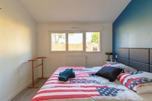 a bedroom with a large bed with an american flag blanket at La Maison Tulipe à Plaisance du Touch in Plaisance-du-Touch