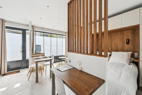 une chambre avec un lit et un bureau dans l'établissement Le Studio Scandinave - 25min de Paris, à Courbevoie
