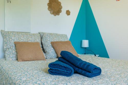 a bed with blue towels sitting on top of it at La Maison Tulipe à Plaisance du Touch in Plaisance-du-Touch
