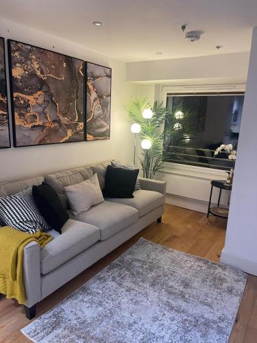 a living room with a couch and a window at New 1 Bed Apartment 12 mins to Central London and Gatwick Airport in Croydon