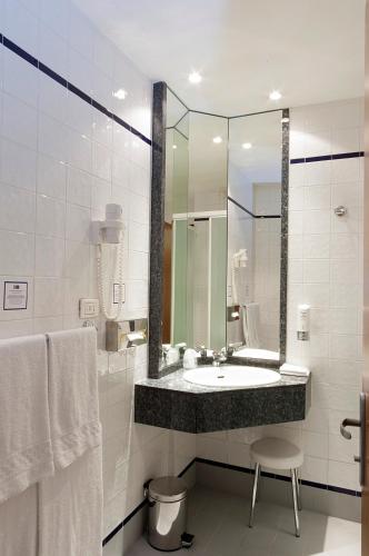 a bathroom with a sink and a mirror at City Hotel & Suites in Foligno