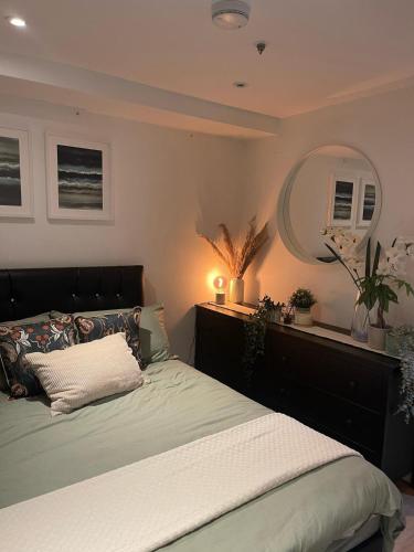 ein Schlafzimmer mit einem Bett und einem großen Spiegel in der Unterkunft New 1 Bed Apartment 12 mins to Central London and Gatwick Airport in Croydon