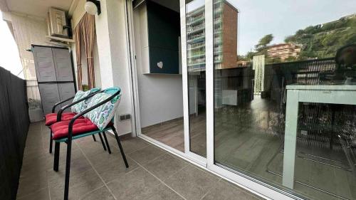 a balcony with a table and a chair and a window at Pequeño oasis en el maresme in Santa Susanna