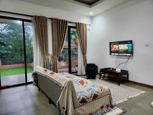 a bedroom with a bed and a flat screen tv at Five Leo’s villa in Gadok 1