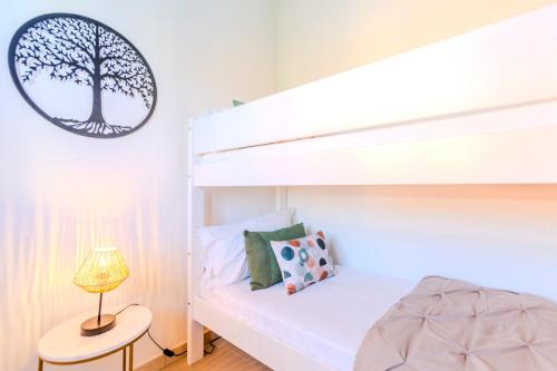 Un dormitorio con una litera con un cuadro de un árbol en la pared. en Villa Emerald private compound swimming pool, en SantʼAnna Arresi