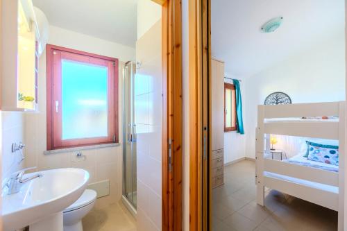 Un baño blanco con lavabo e inodoro. en Villa Emerald private compound swimming pool, en SantʼAnna Arresi