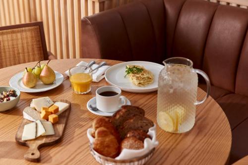 a table with plates of breakfast food and a pitcher of juice at Jacob Resort Hadera in H̱adera