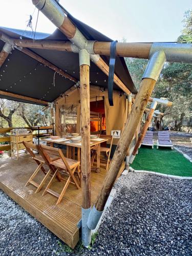 a wooden deck with a table and chairs at Camper Village in Santo Stefano al Mare