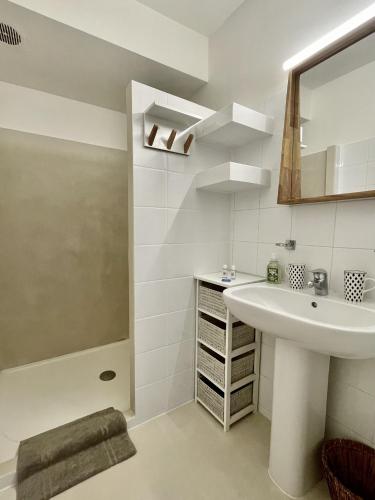 une salle de bain blanche avec un lavabo et une douche dans l'établissement GIGARO - Terrasses et jardin à 5mn à pied de la plage - piscine & parking, à La Croix-Valmer