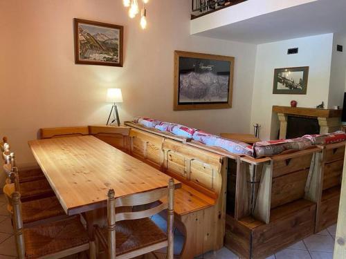 Cette chambre comprend une grande table en bois et un canapé. dans l'établissement Apartment Ciel Étoilé, à Les Coches