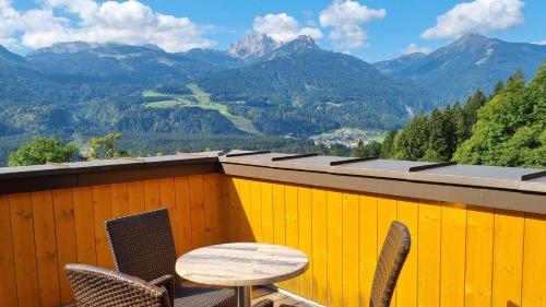 a table and chairs on a balcony with mountains at nawu apartments & Restaurant in Hermagor