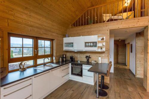 a kitchen with white cabinets and a wooden ceiling at Chalet Hüttenzauber in Mehlmeisel