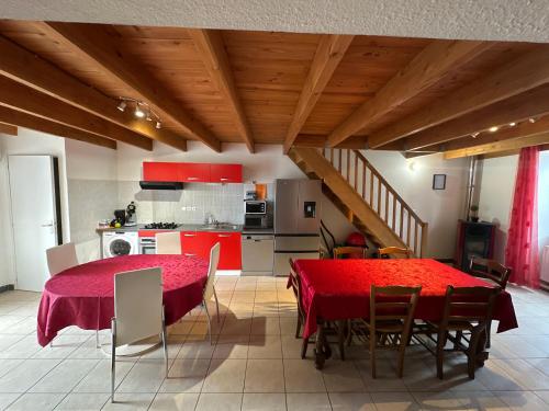 une cuisine et une salle à manger avec une table et des chaises rouges dans l'établissement La Volta, à La Voulte-sur-Rhône