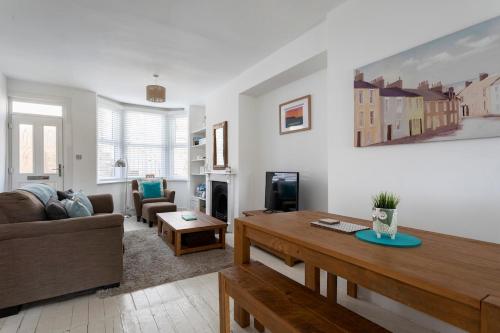 a living room with a couch and a table at Just Beachy - 2 Bedroom Traditional cosy fisherman's cottage in Scarborough