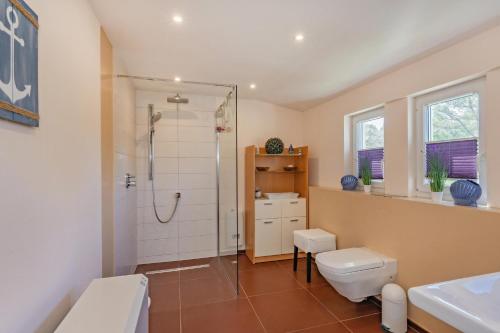 Un baño con ducha, inodoro y lavabo. en Strandhaus Möwe, en Zempin