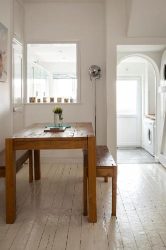 a dining room with a wooden table and a window at Just Beachy - 2 Bedroom Traditional cosy fisherman's cottage in Scarborough