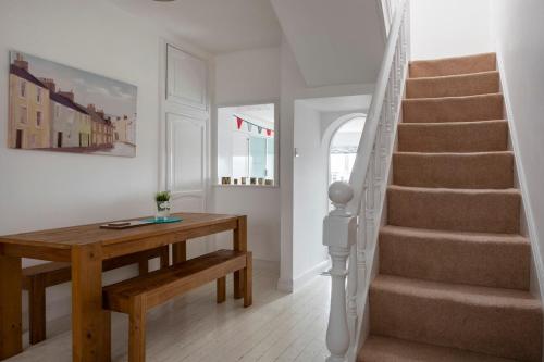 a stairway with a wooden table and a stair case at Just Beachy - 2 Bedroom Traditional cosy fisherman's cottage in Scarborough