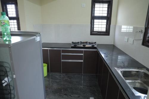 a kitchen with a stove and a sink in it at 2BHK Fully Furnished house Mangalore in Mangalore