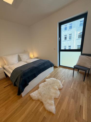 ein Schlafzimmer mit einem Bett und einem großen Fenster in der Unterkunft ElbeCity Apartment in Dresden