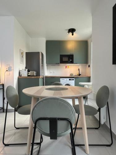 une cuisine avec une table et des chaises dans une pièce dans l'établissement Casa Candela, à Magny-le-Hongre