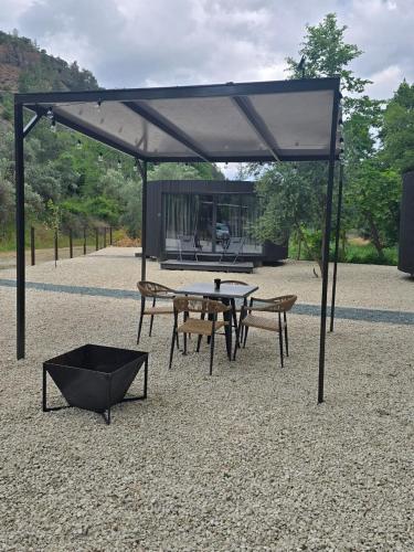 a picnic table and chairs under a canopy at River Glamping Kalopanayiotis in Kalopanayiotis