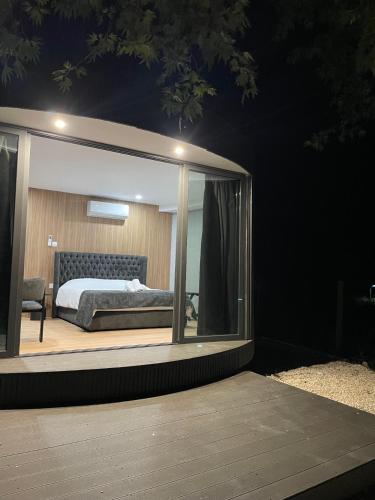 a bedroom with a large window with a bed in it at River Glamping Kalopanayiotis in Kalopanayiotis