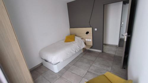 une petite chambre avec un lit dans une pièce dans l'établissement Garoupe T3 Bloom Le Spot, à La Ciotat