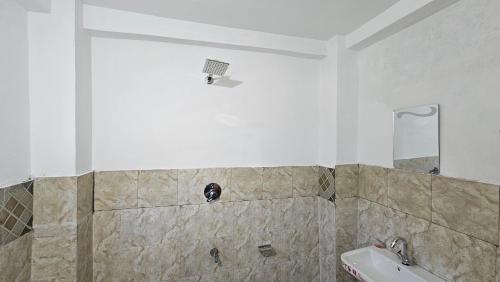 a bathroom with a shower and a sink at Freebird Nest Retreat in Jibhi
