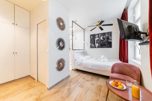 une petite chambre avec un lit et une table dans l'établissement Studio lumineux et moderne proche du metro - 2P, à Paris