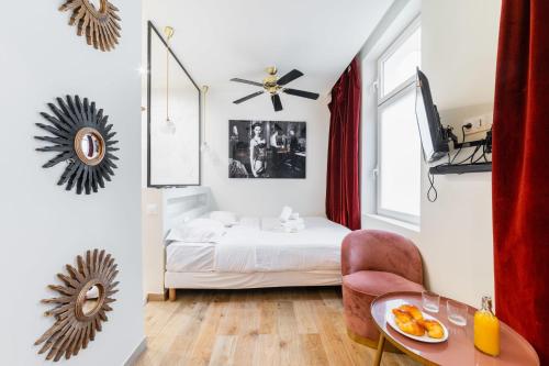 - une chambre avec un lit et une table avec une assiette de nourriture dans l'établissement Studio lumineux et moderne proche du metro - 2P, à Paris