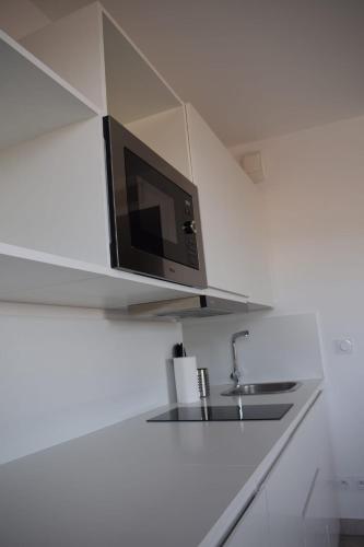 - un four micro-ondes sur une étagère au-dessus d'un évier dans la cuisine dans l'établissement Garoupe T3 Bloom Le Spot, à La Ciotat