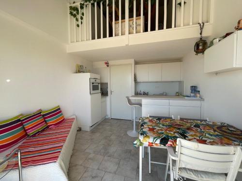 - une petite cuisine avec une table et un canapé dans l'établissement Duplex Cozy - Piscine - Vue Mer, à Carqueiranne